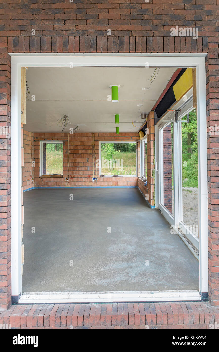 Look through at new house with concrete floor inside Stock Photo