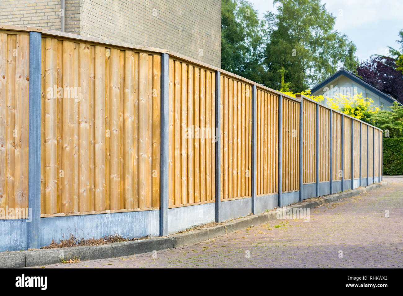 New wooden fence along the road in residential area Stock Photo