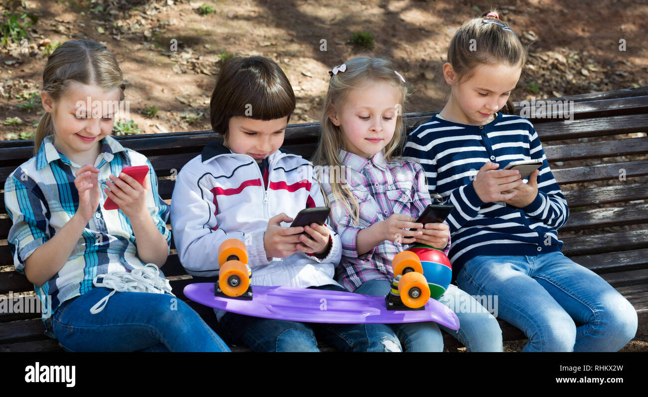 Outdoor portrait of kids playing with phones Stock Photo - Alamy