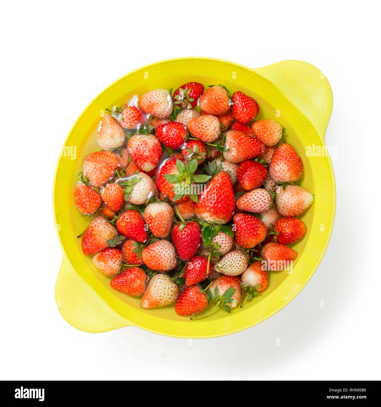 fresh red strawberry soaking in water in plastic bowl Stock Photo