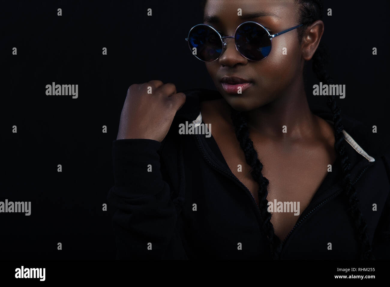 Confident african woman with dark skin wearing round sunglasses Stock