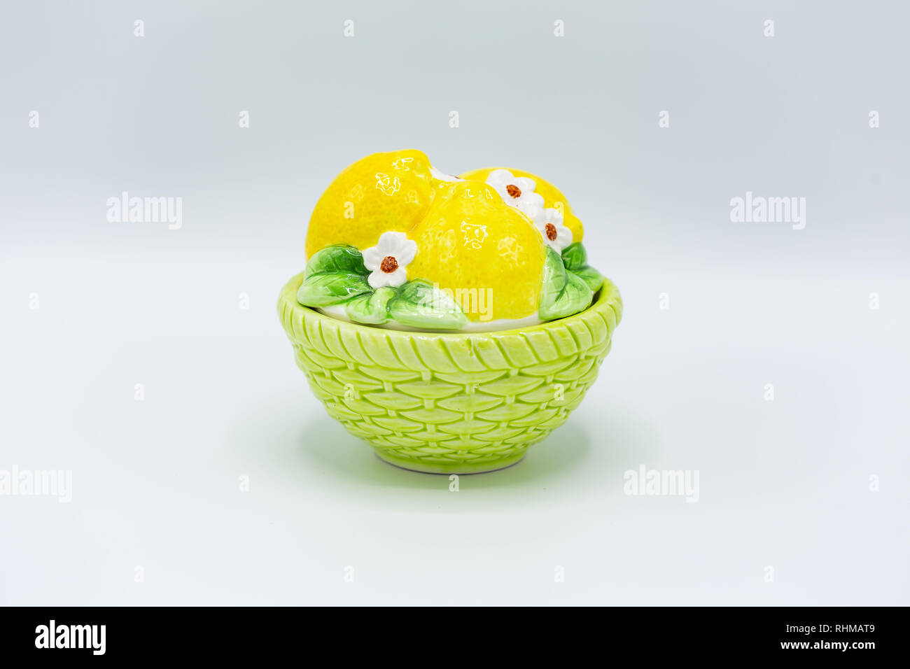 a round candy dish with green bottom and lemons on the lid Stock Photo