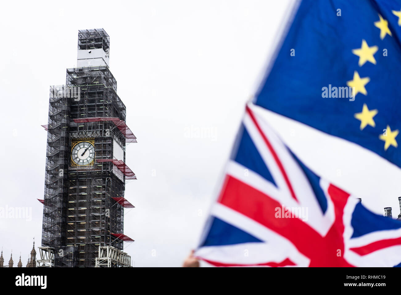Big Ben at Parliament covered in scaffolding with the Union Fag and European Union Flag in the foreground. London UK Stock Photo