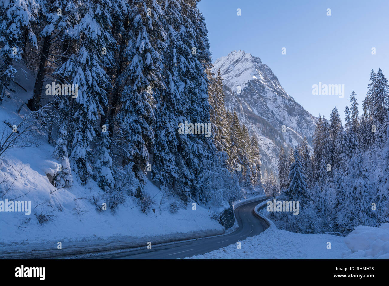 Road to snowy mountain in Austrian Alps. The road to Kaunertal, Tyrol, Austrian Alps, in winter time, with snow covered trees and mountain crests Stock Photo