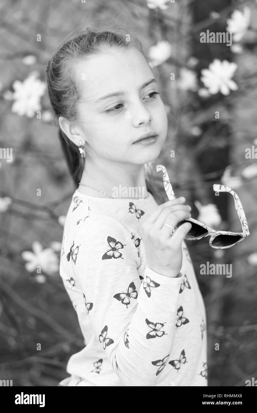 Cute baby girl with flowers over nature background. Spring portrait. Stock Photo