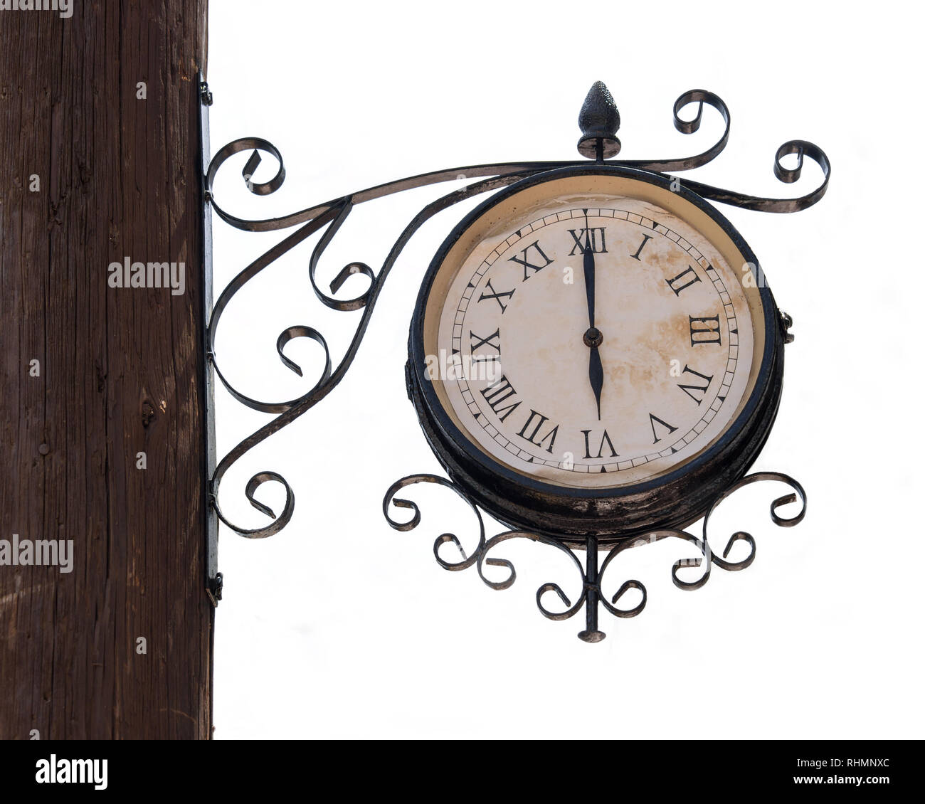 Vintage street clock on a wooden pole isolated on white background Stock Photo