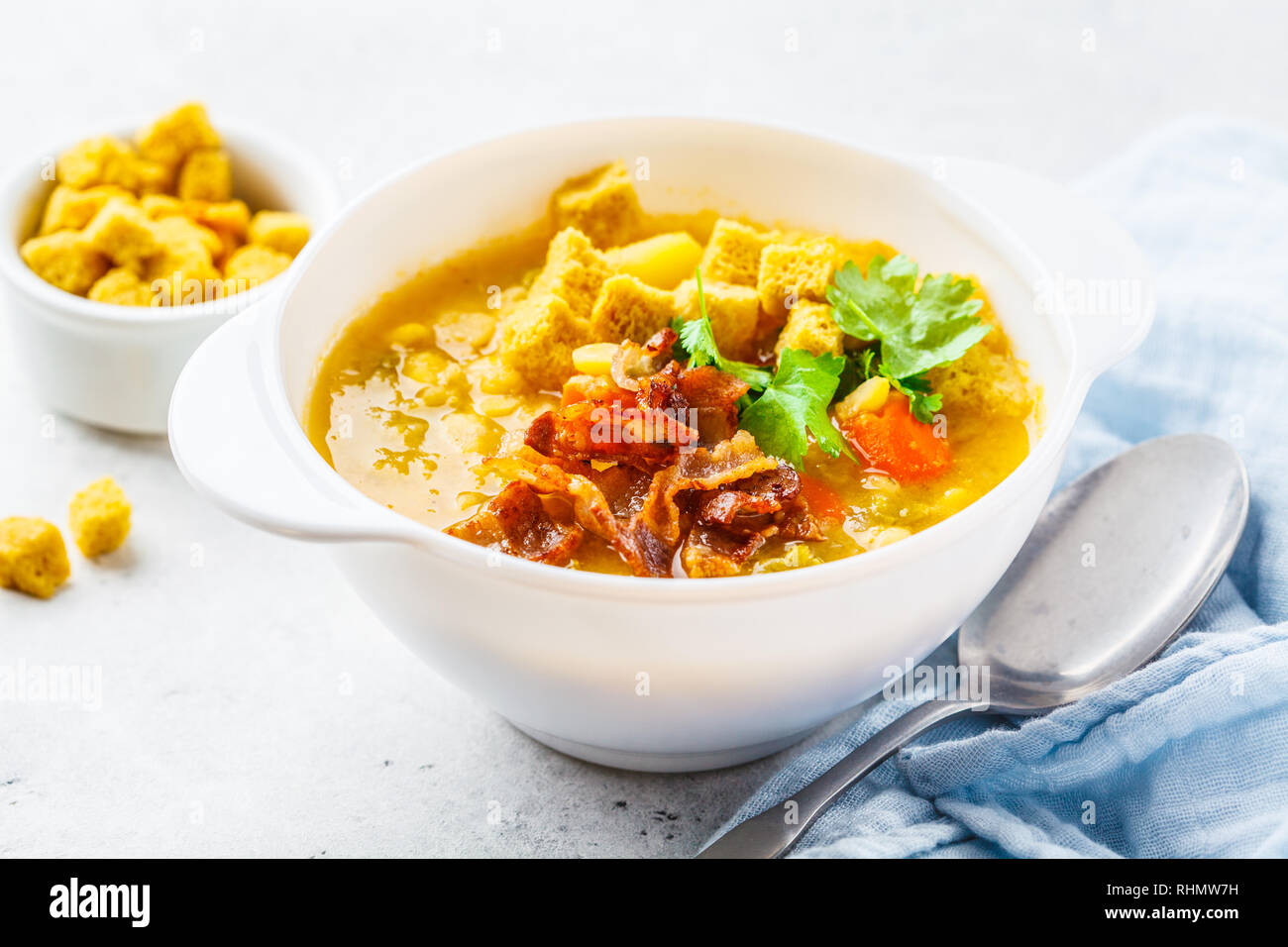 Split pea soup with smoked bacon and crackers in a white plate Stock