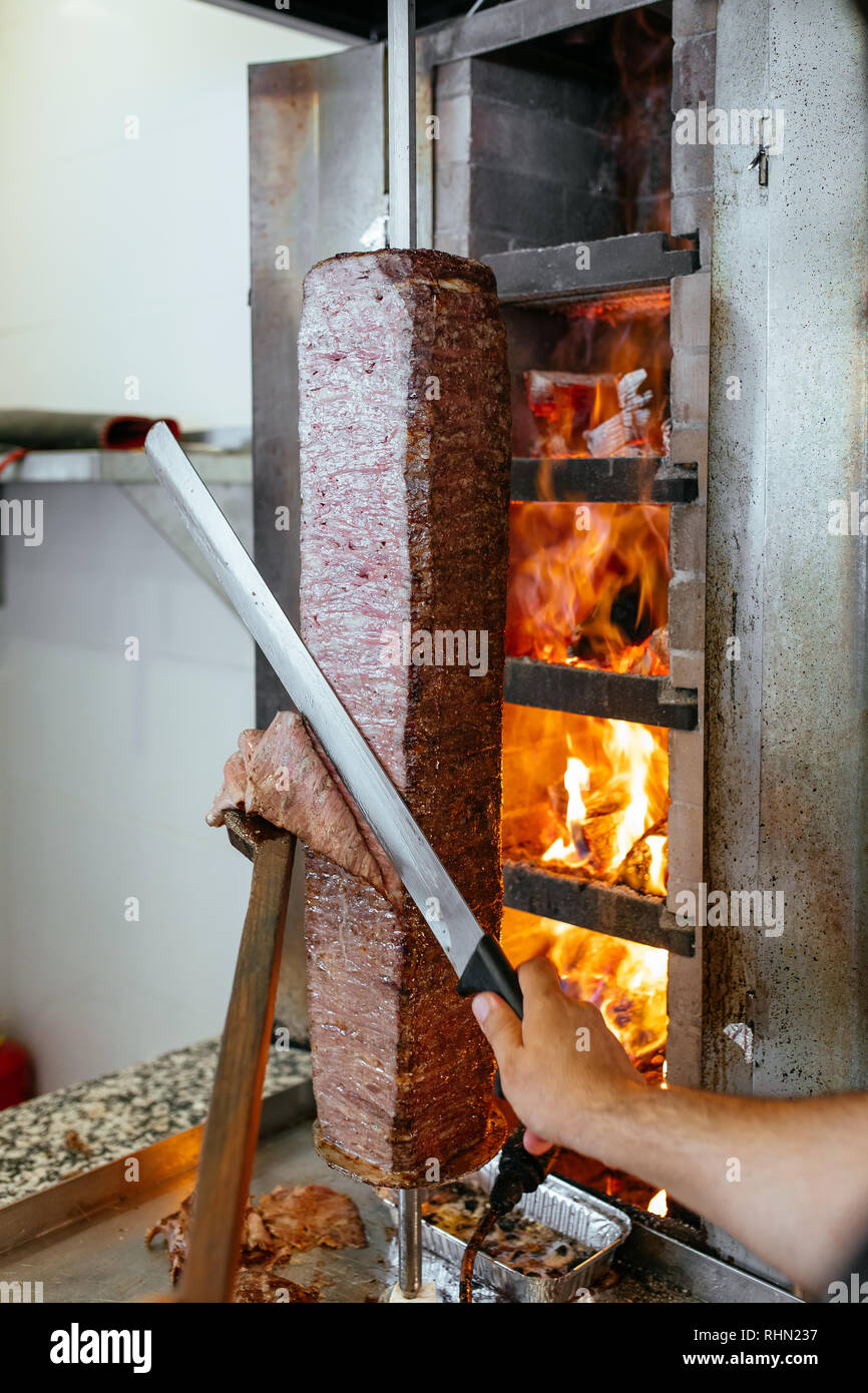 Turkish Doner Kebab, Shawarma or Gyros. Chef cutting with doner ...