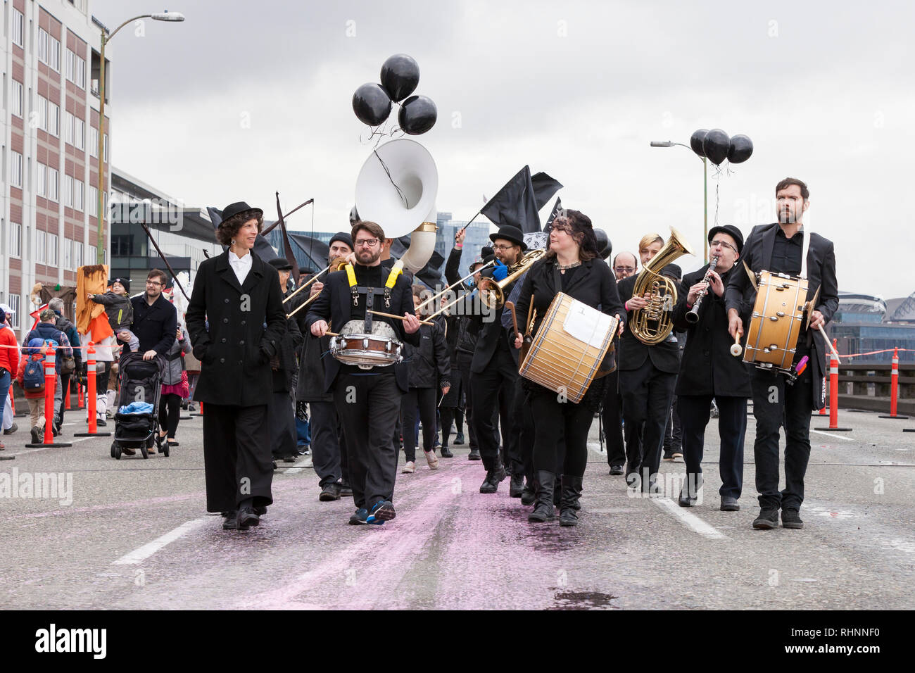 Seattle, Washington, USA. 2nd February, 2019. Orkestar Zirkonium and Friends brass-and-drum band, dressed in black to mourn the loss of the landmark road, leads a procession along the closed Alaskan Way Viaduct. An estimated 70,000 people attended the Hello Goodbye: Viaduct Arts Festival as part of the grand opening of the state-of-the-art tunnel spanning two-miles under downtown. The festival, which took place on the elevated highway, began with a processional featuring music and performances from regional artists and organizations. Credit: Paul Christian Gordon/Alamy Live News Stock Photo