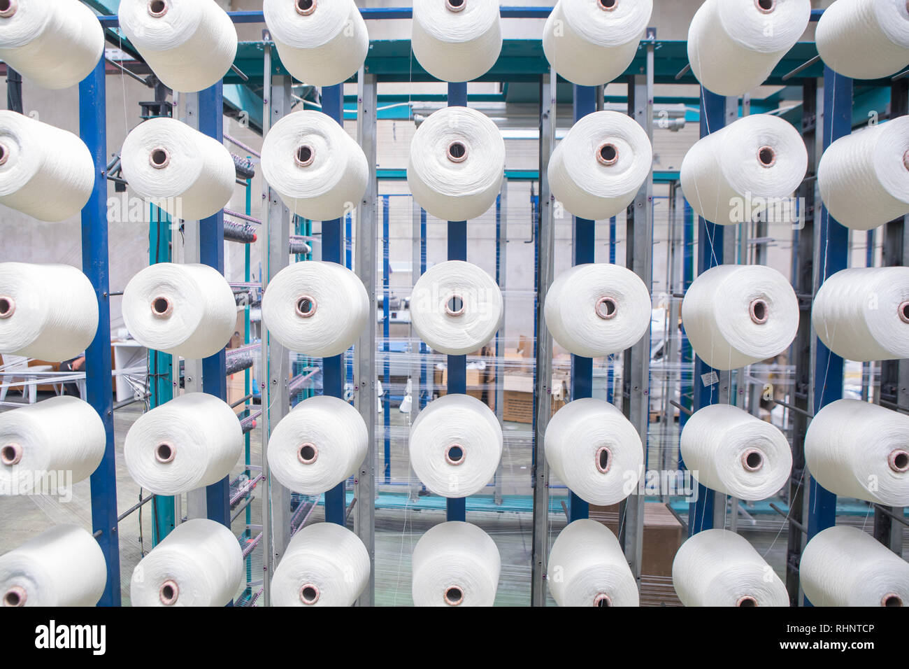 Group of bobbin thread cones on a warping machine in a textile mill