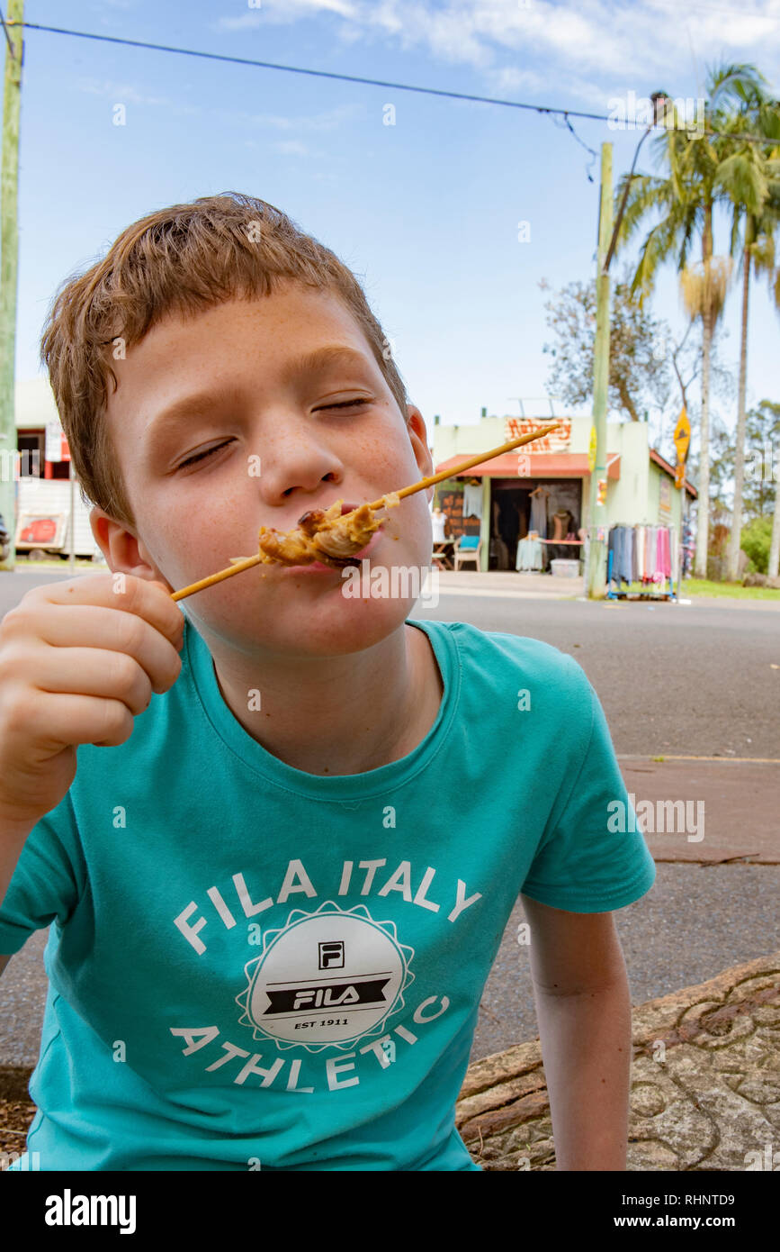 Boy eats a kebab, street eats in Nimbin, New South Wales, Australia Stock Photo