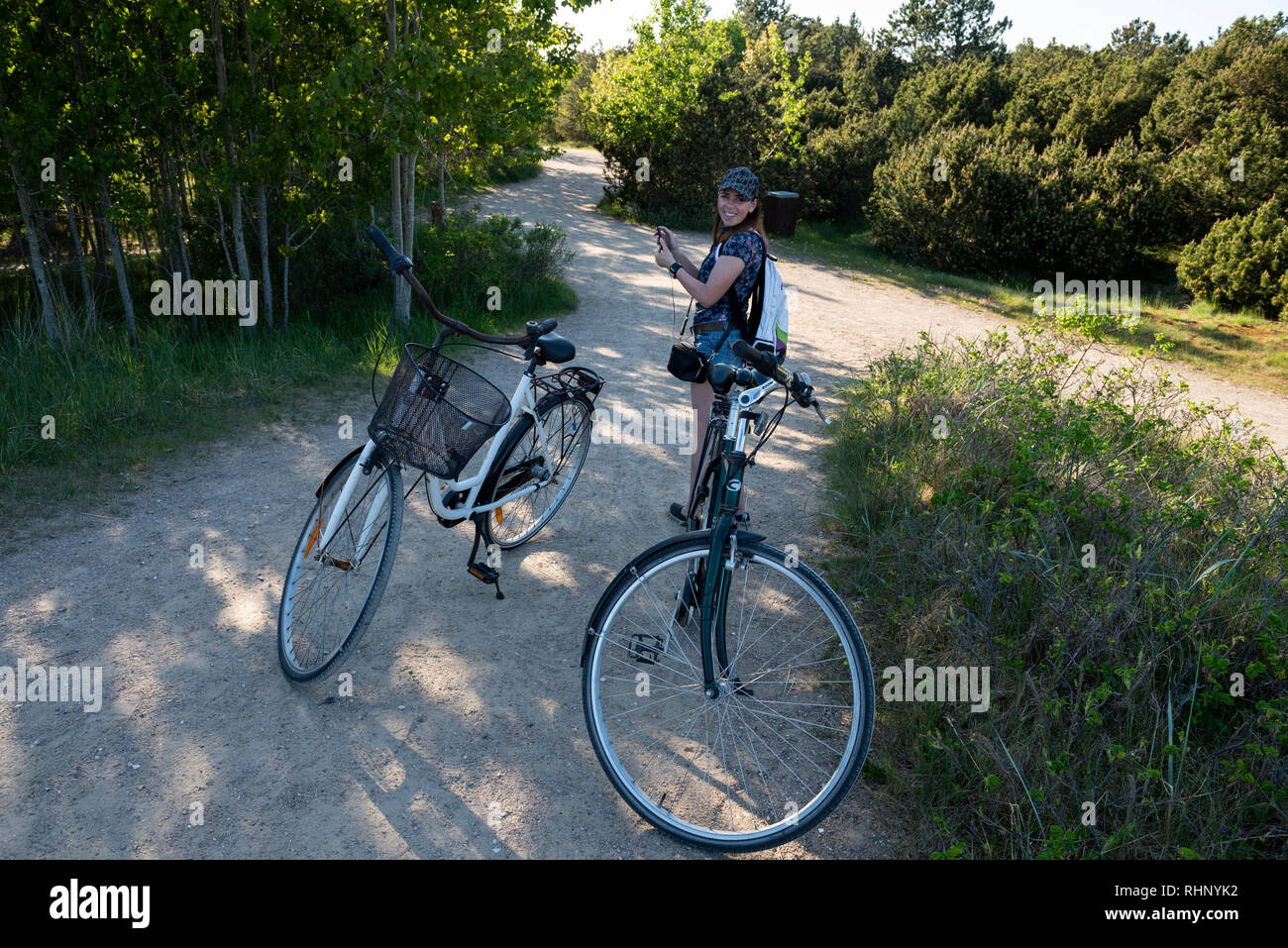 A woman standing on the sandy forest road next to the parked bicycles in  Skagen, Denmark Stock Photo - Alamy