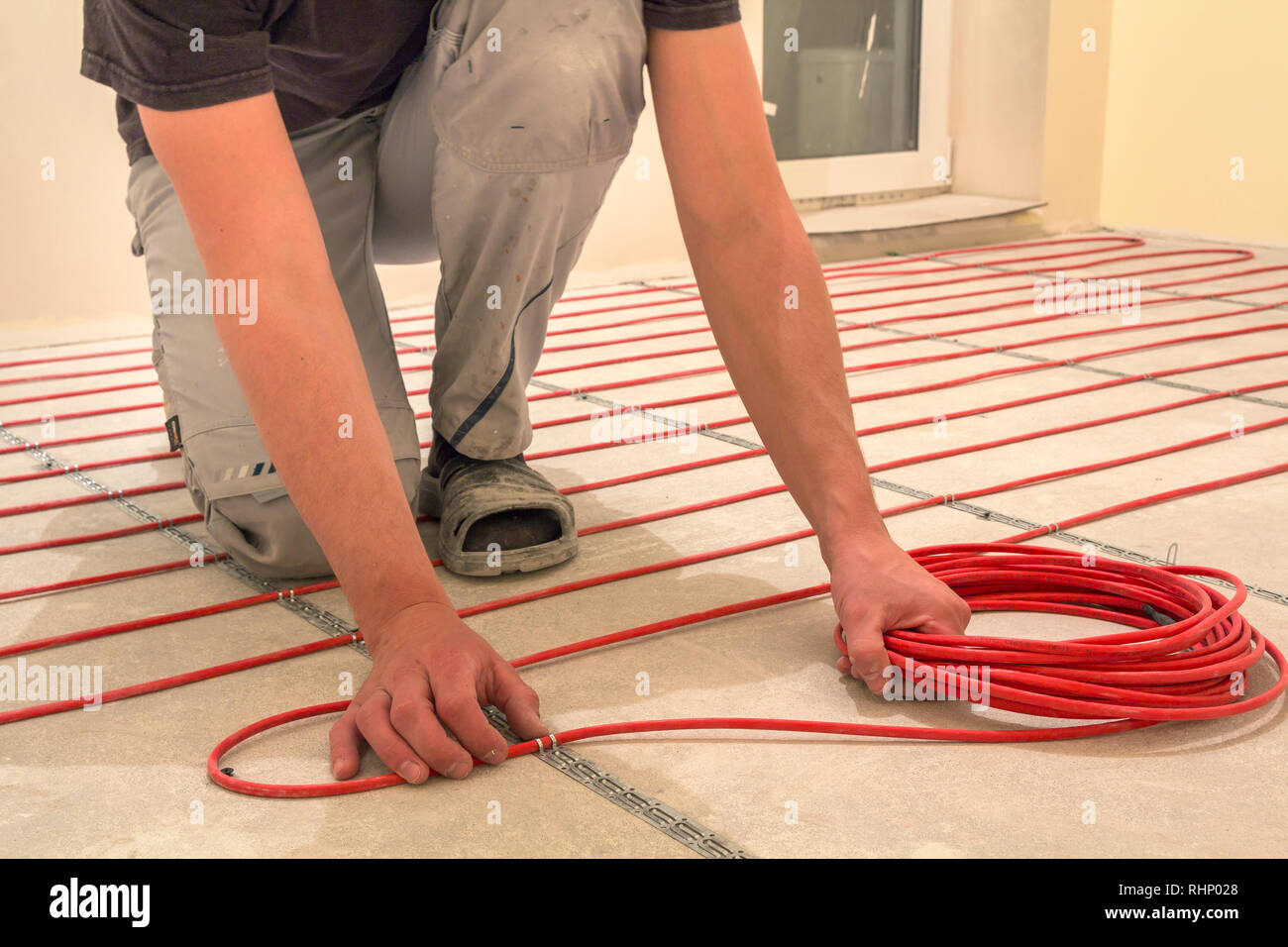 Electrician Installing Heating Red Electrical Cable Wire On