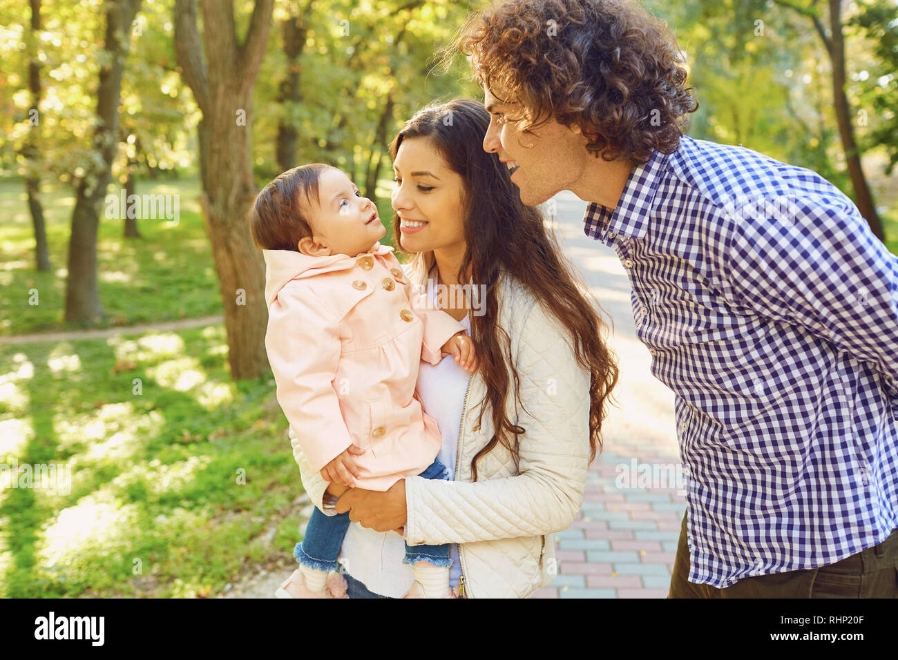 Happy family standing playing in the park Stock Photo - Alamy