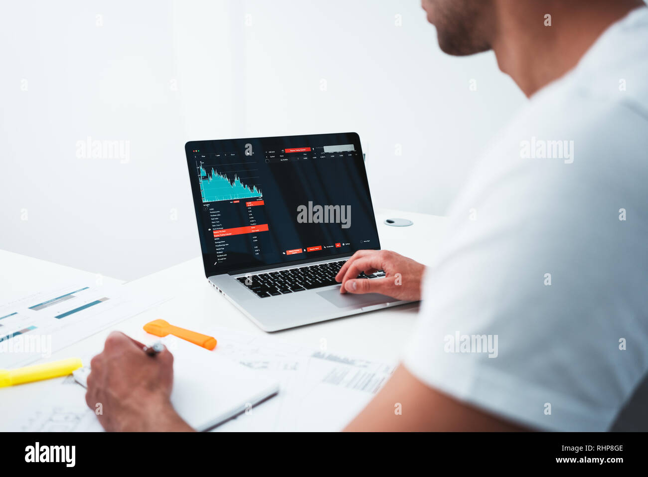 Creative building designer working with drawing plan and computer while sitting by table at studio office. Young architect using laptop and blueprint  Stock Photo