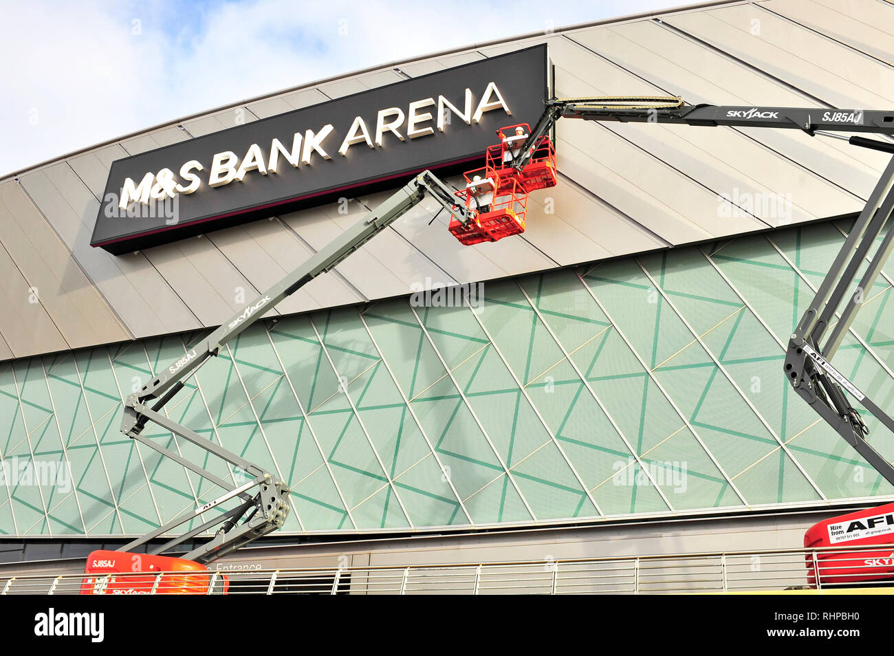 Workers in Sky Jack hoists cleaning the front of the M&S Bank Arena (formerly the Liverpool Echo Arena) on King's Dock, Merseyside Stock Photo