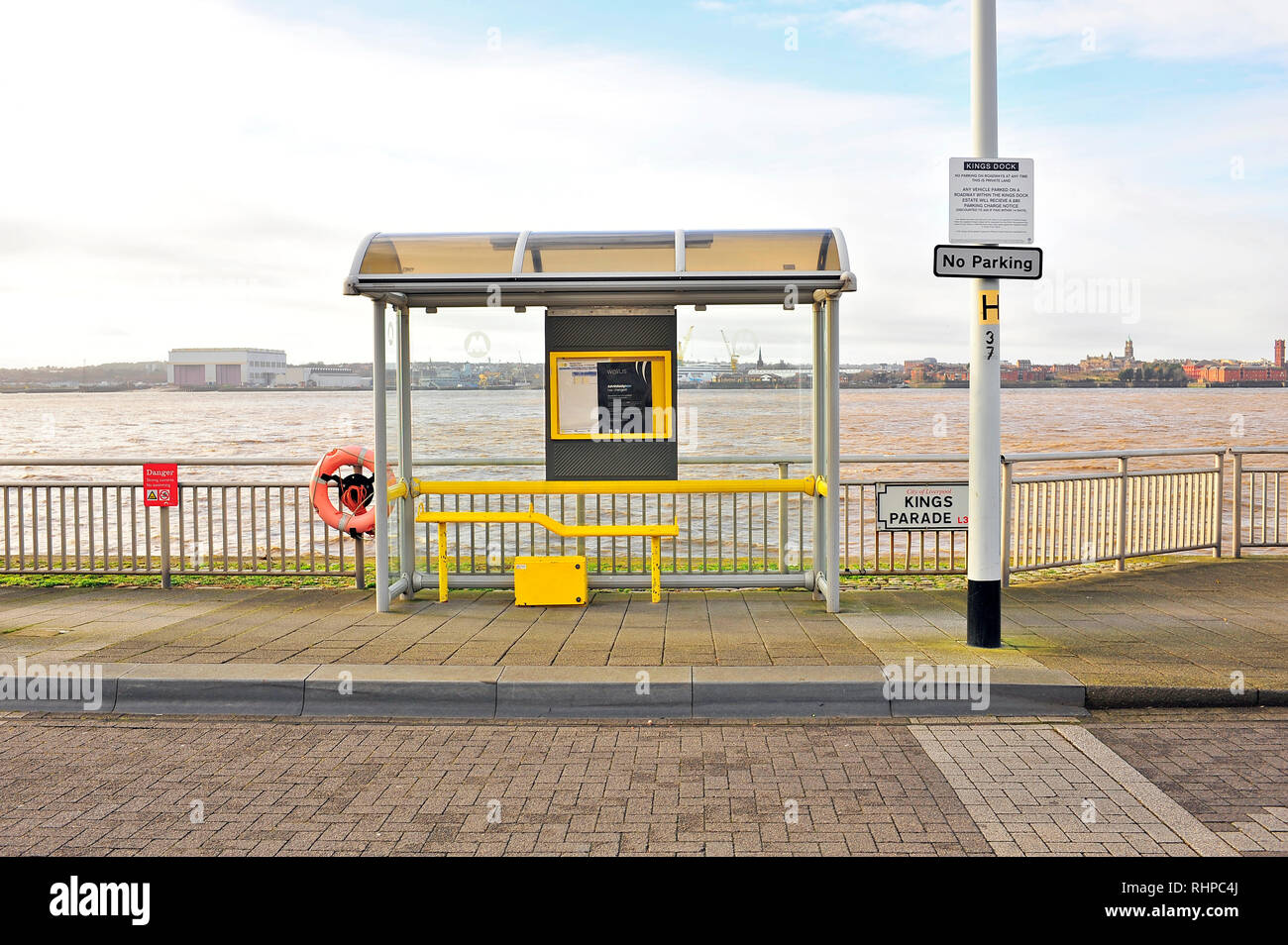 Empty bus shelter on Kings Parade,Liverpool,with the River Mersey and Birkinhead in the background Stock Photo