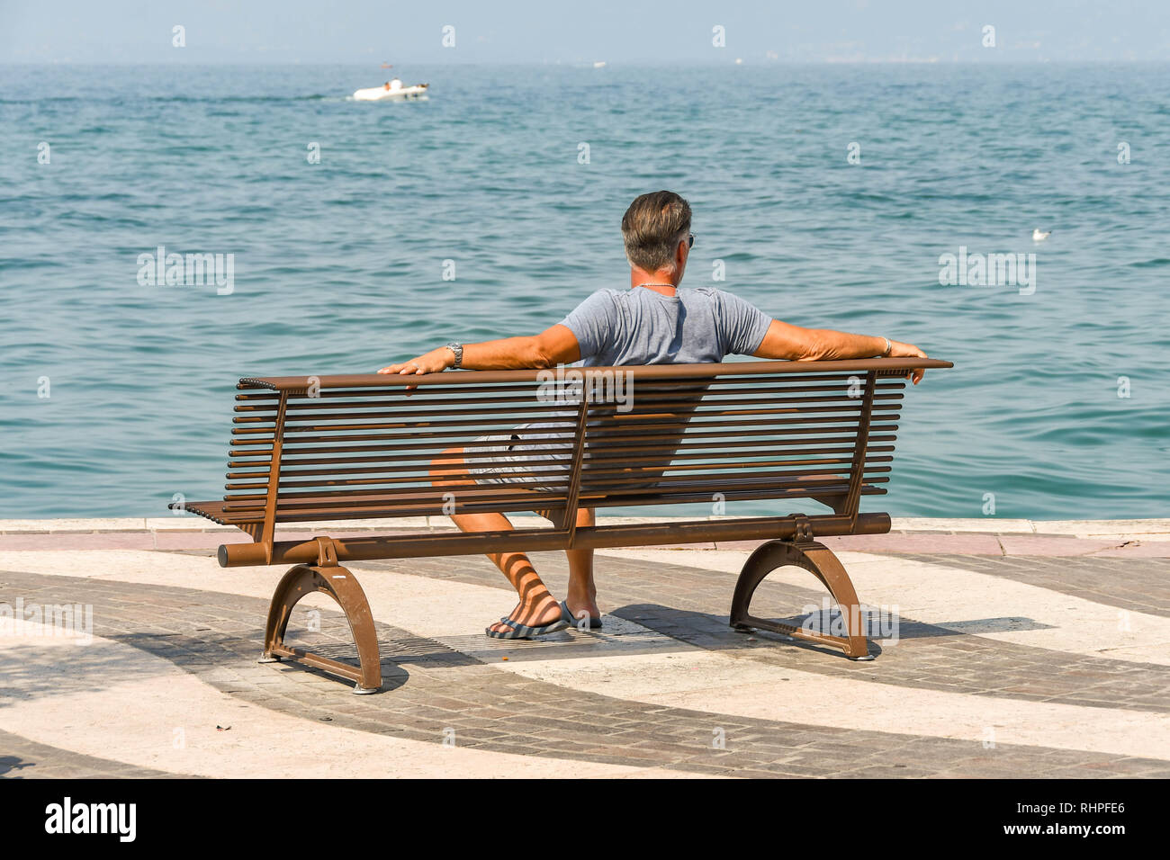 Man sitting on lake garda waterfront hi-res stock photography and ...