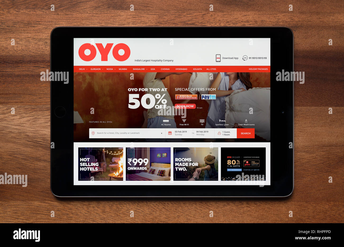 The website of OYO Rooms is seen on an iPad tablet, which is resting on a wooden table (Editorial use only). Stock Photo