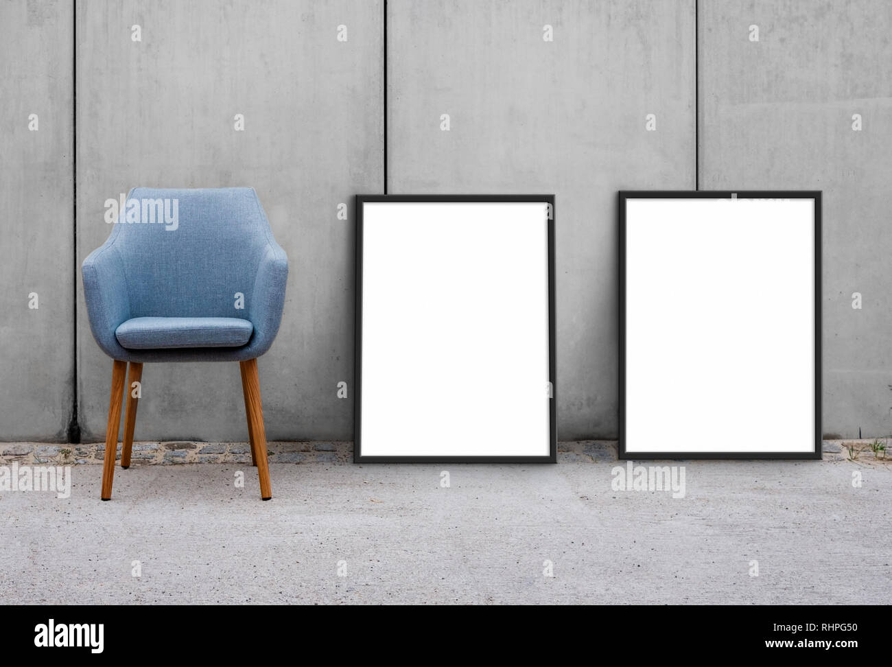chair and blank picture frames on sidewalk with concrete wall background Stock Photo