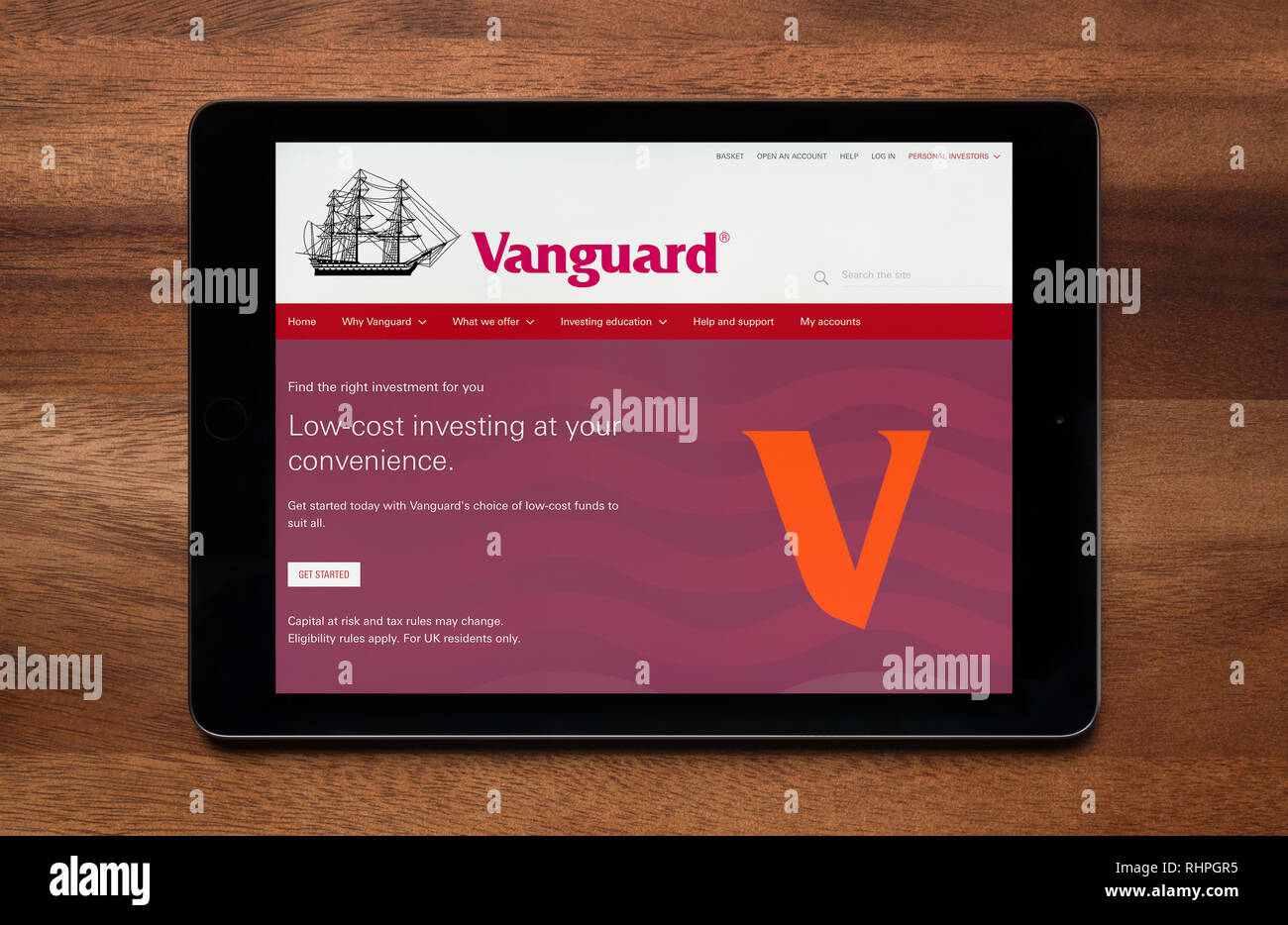 The website of Vanguard is seen on an iPad tablet, which is resting on a wooden table (Editorial use only). Stock Photo