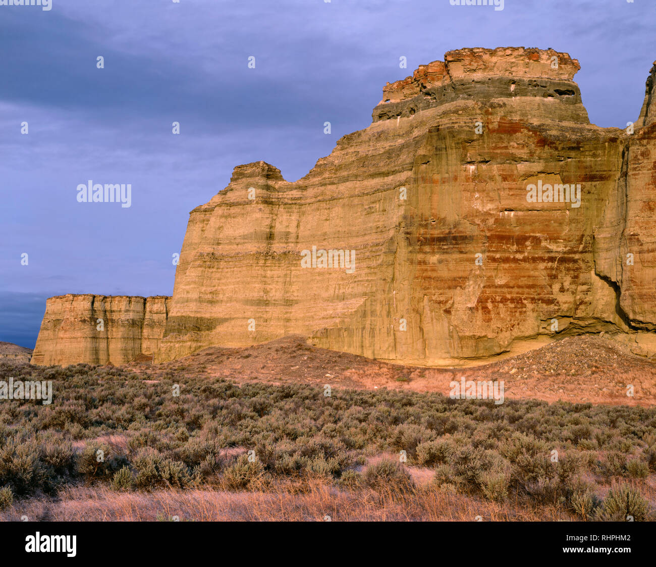 USA, Oregon, Malheur County, Clouds at sunrise over formation of fossil-bearing clay called the Pillars of Rome and surrounding sagebrush plain. Stock Photo