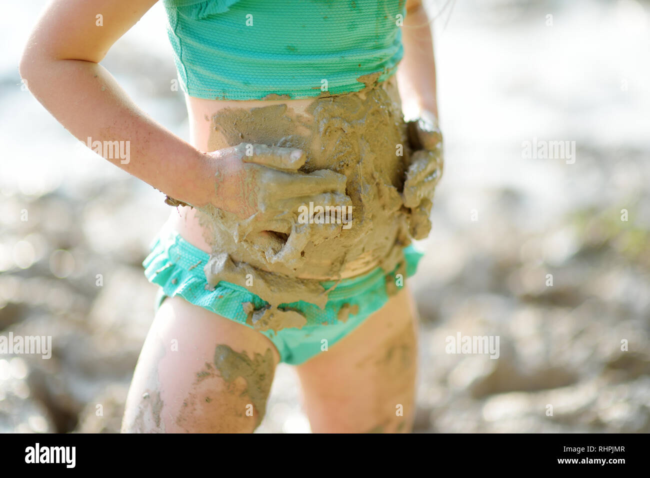 Young girl taking healing mud baths on lake Gela near Vilnius