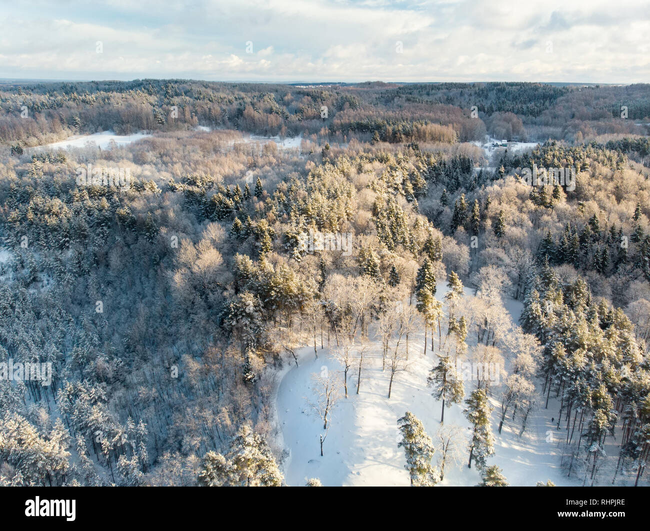 Beautiful aerial view of snow covered pine forests and a road winding ...