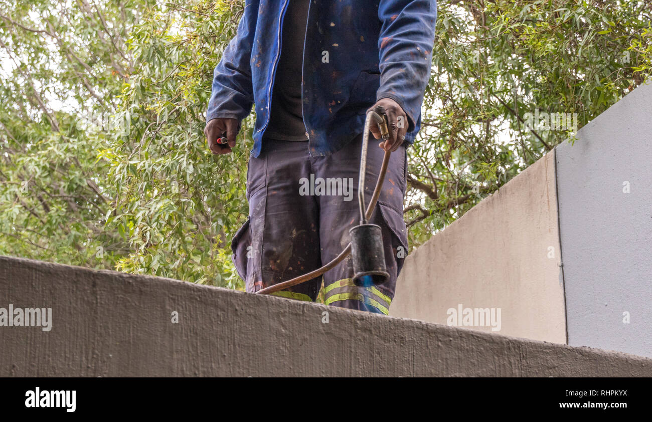 Roofing contractor does hot rubber melt roof sealing image with copy