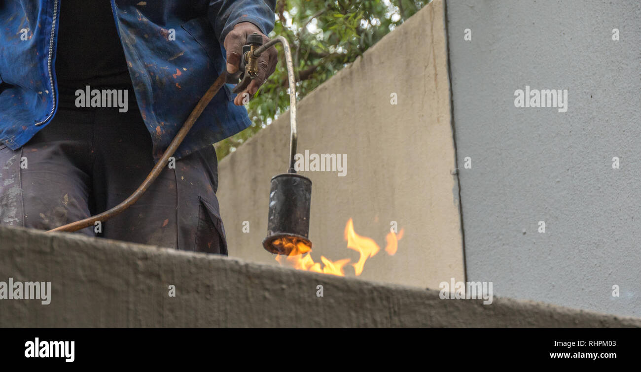 Roofing contractor does hot rubber melt roof sealing image with copy