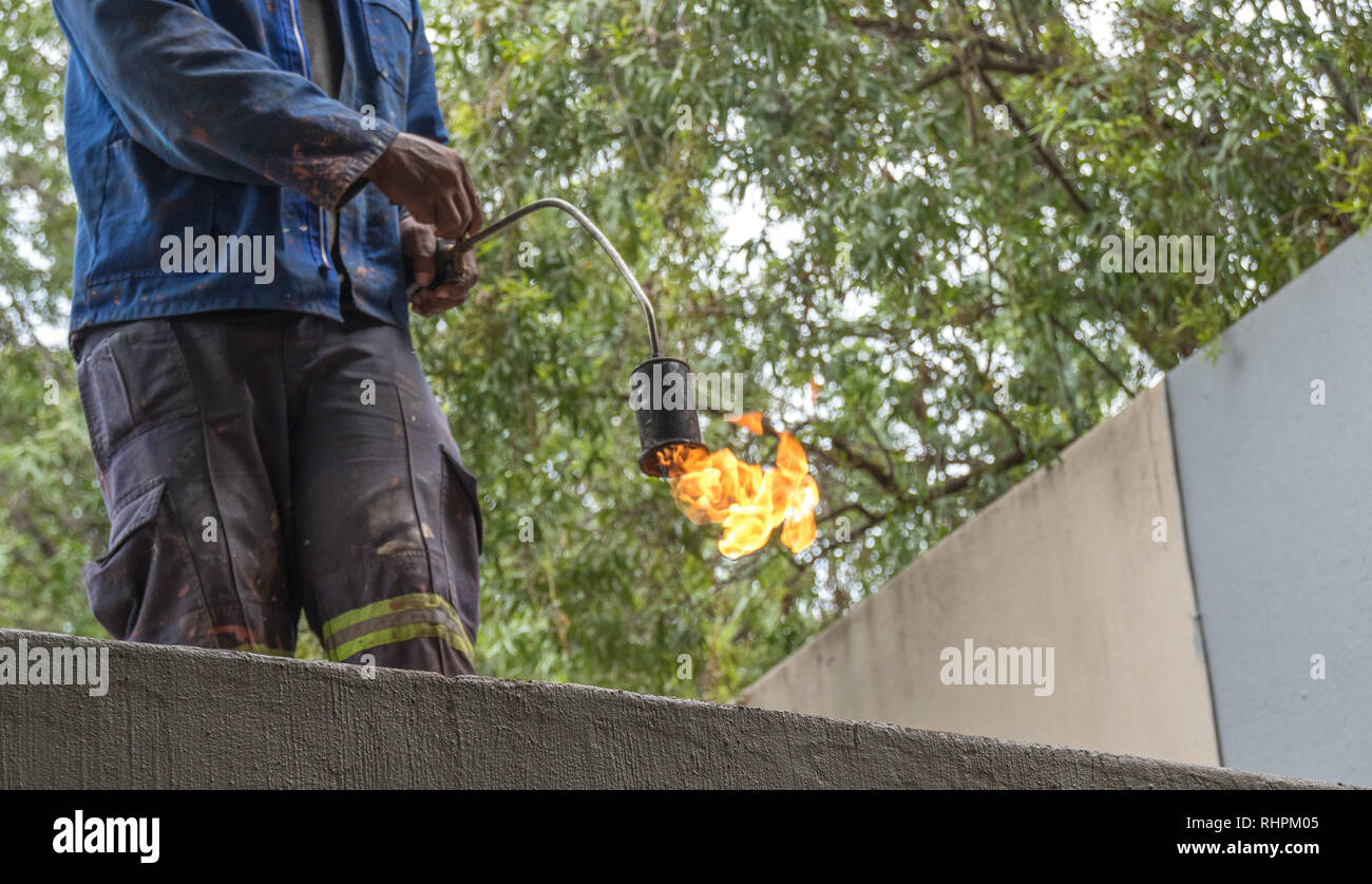 Roofing contractor does hot rubber melt roof sealing image with copy