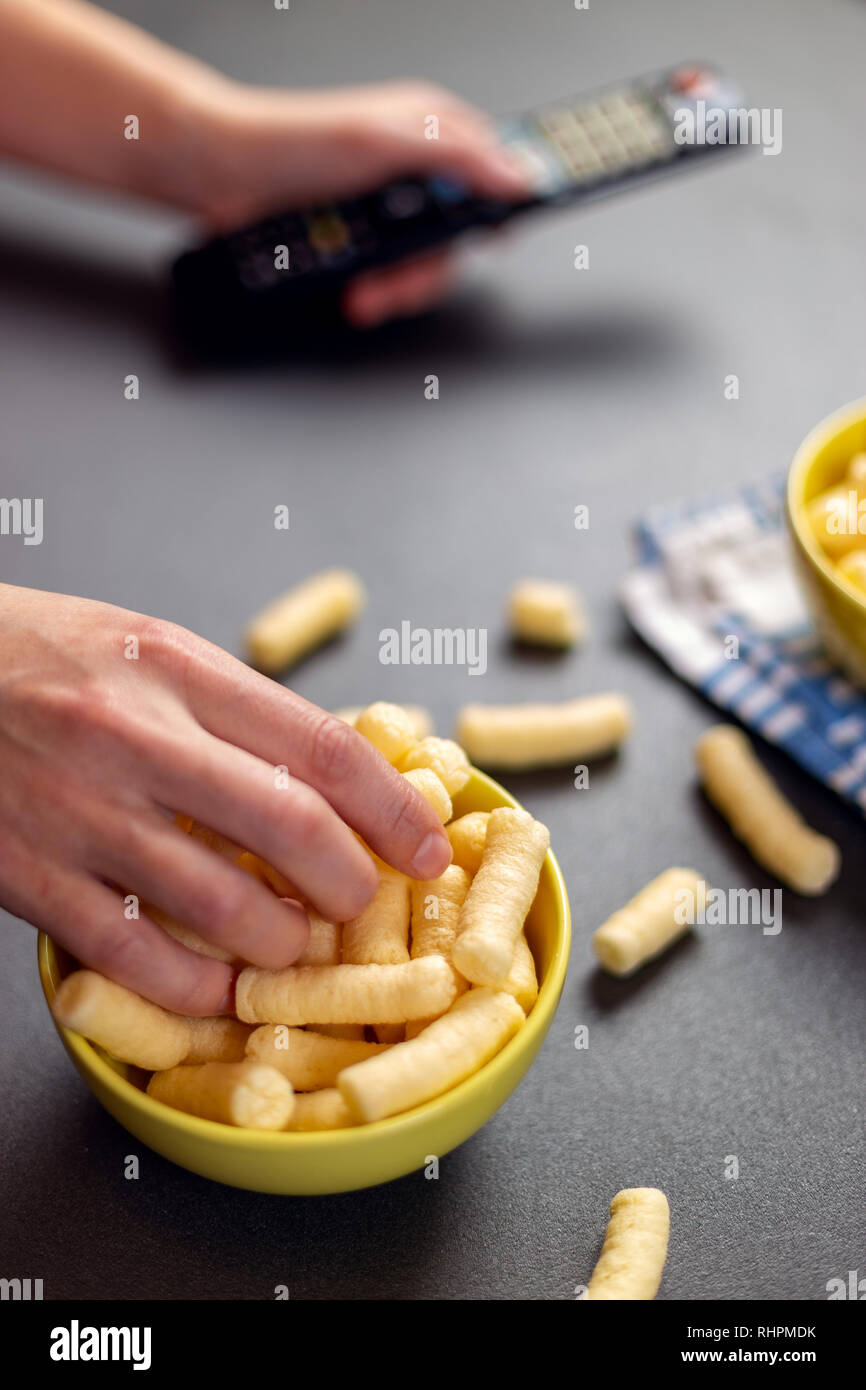 Puffelets Snack Close up of person with corn puffs, pufuleti or corn crisps. Relaxing ...