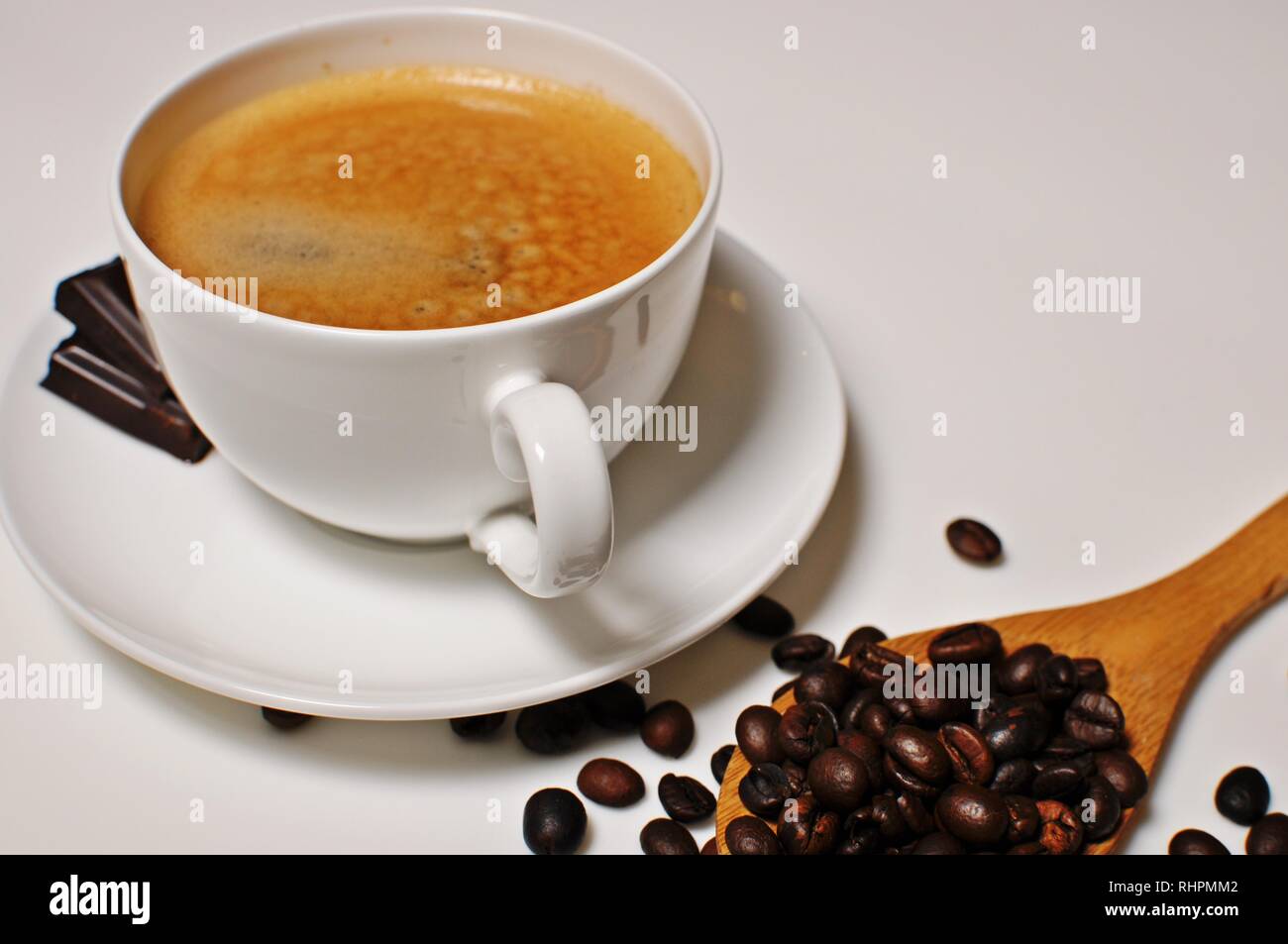 Hot cup of coffee with chocolate and roasted beans as decoration. Stock Photo