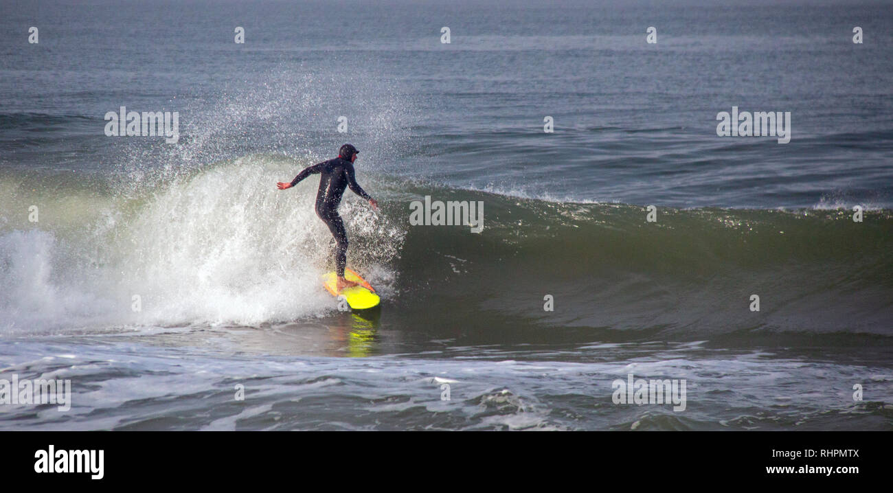 Surfer on wave at sandbar where the Santa Clara River empties into the Pacific Ocean at McGrath State Park in Ventura California United States Stock Photo
