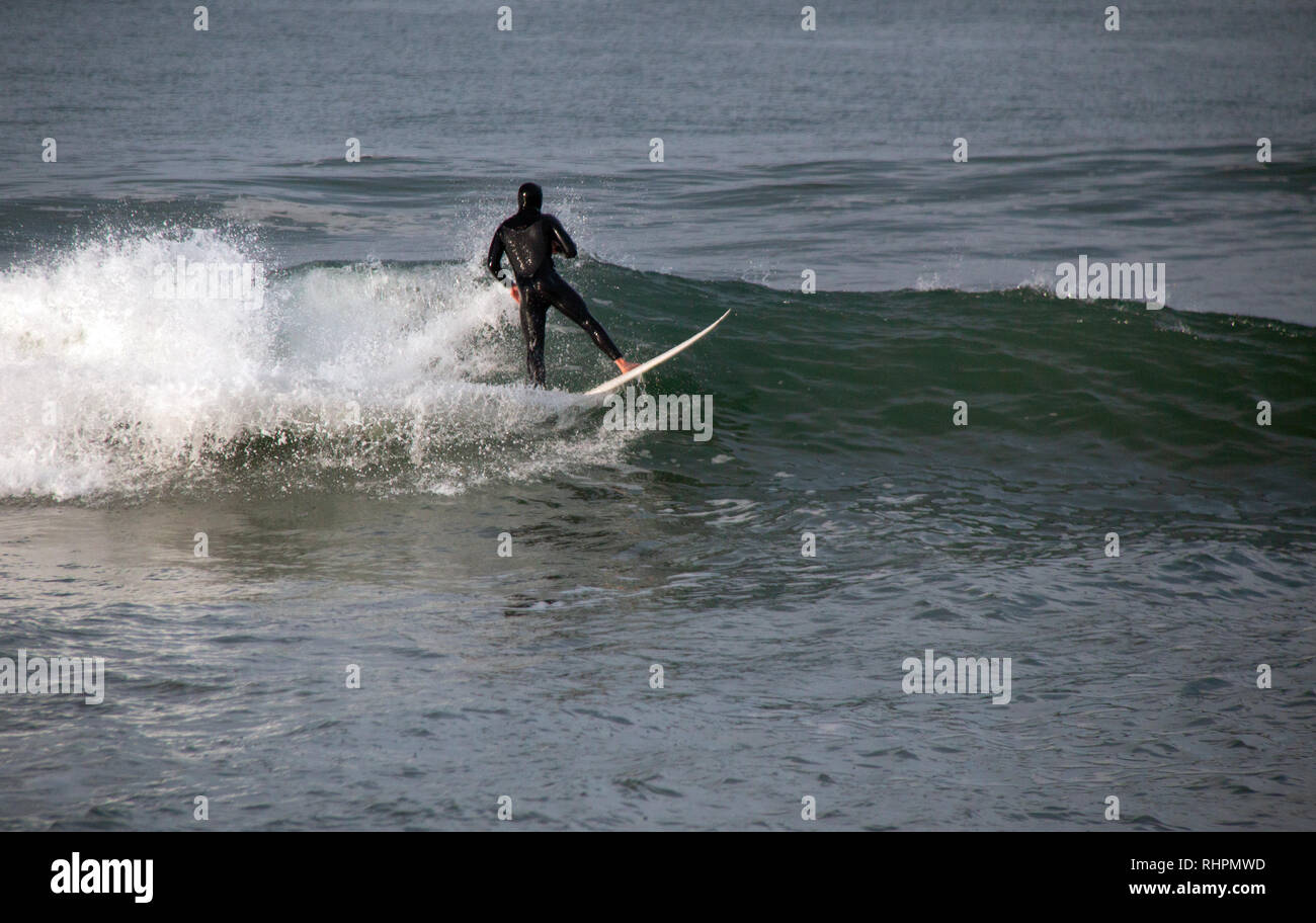Surfer on wave at sandbar where the Santa Clara River empties into the Pacific Ocean at McGrath State Park in Ventura California United States Stock Photo