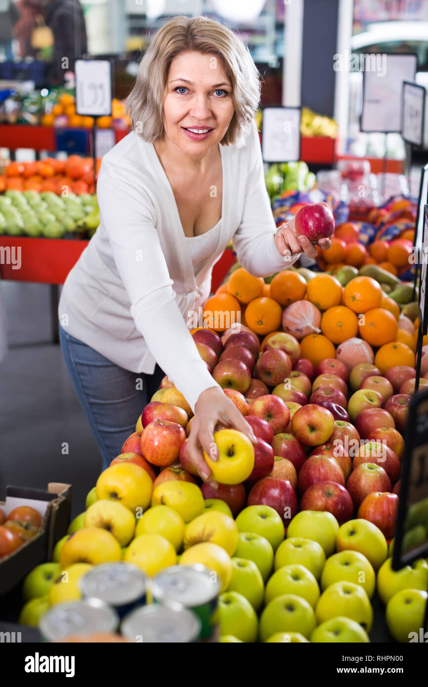 Portrait of happy senior customer selecting fruits in grocery Stock ...