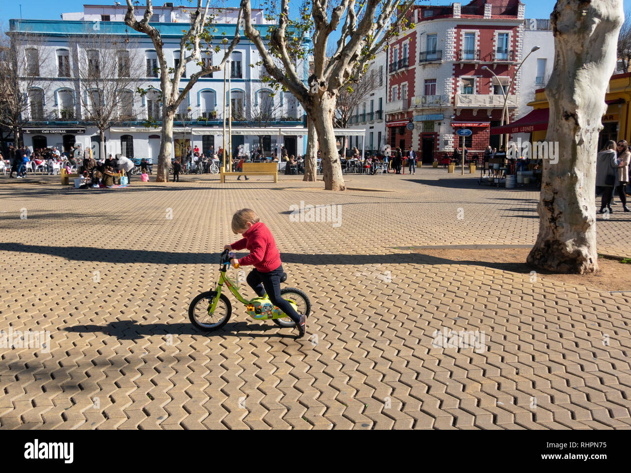 A young boy learning to ride a twowheeled bicycle in the Alameda de