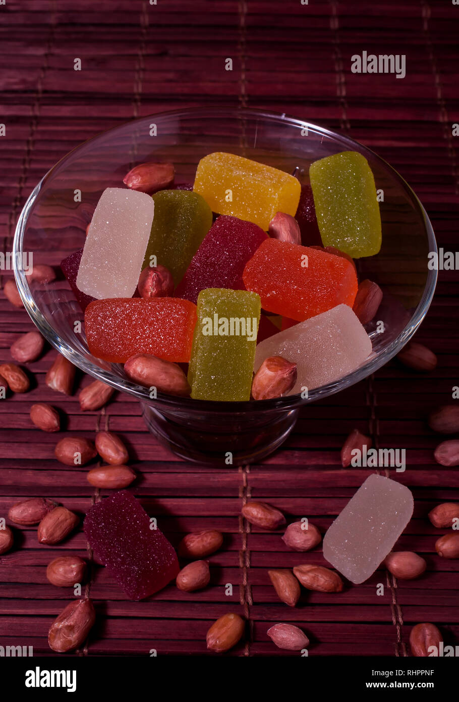 Sweets in glassware on a bamboo napkin. Multicolored jelly candies and peanuts Stock Photo Alamy