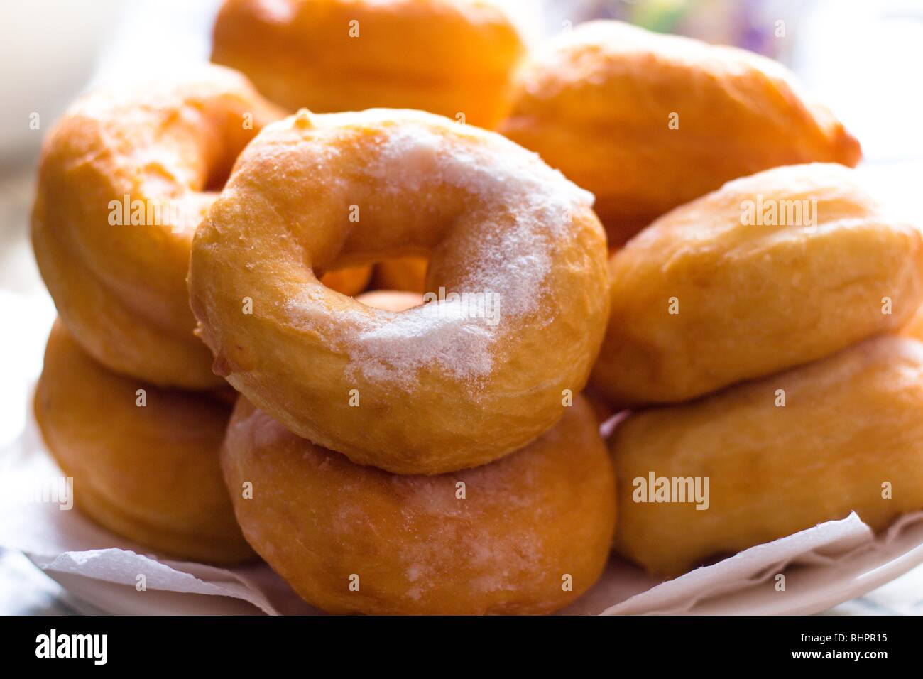 Hot confectioners have just been sentenced and laid out on dishes and sprinkled with powdered sugar. A very tasty flour product for lovers of dessert Stock Photo