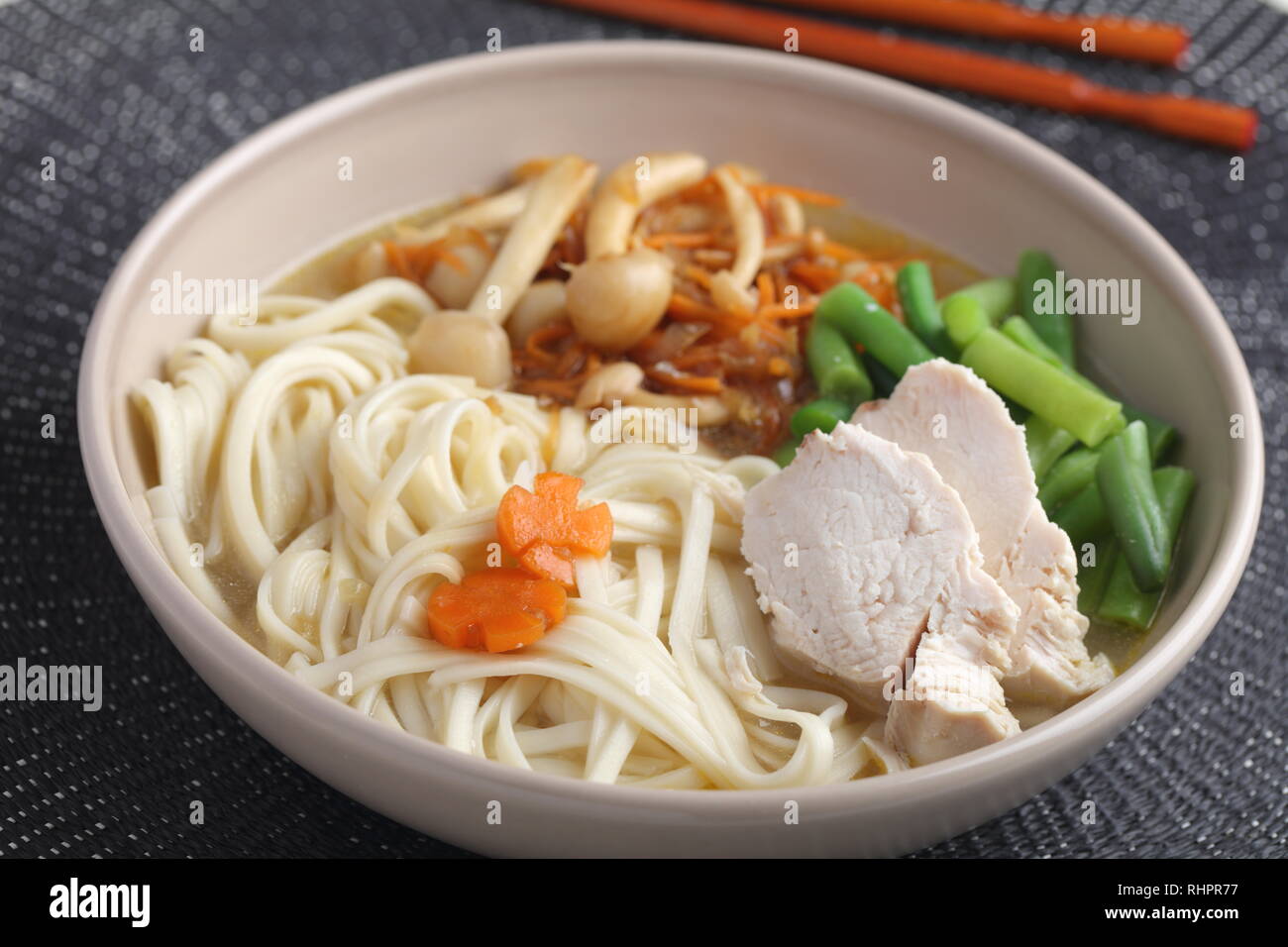 Chicken and udon noodle soup with Shimeji mushrooms, carrot, onion, and