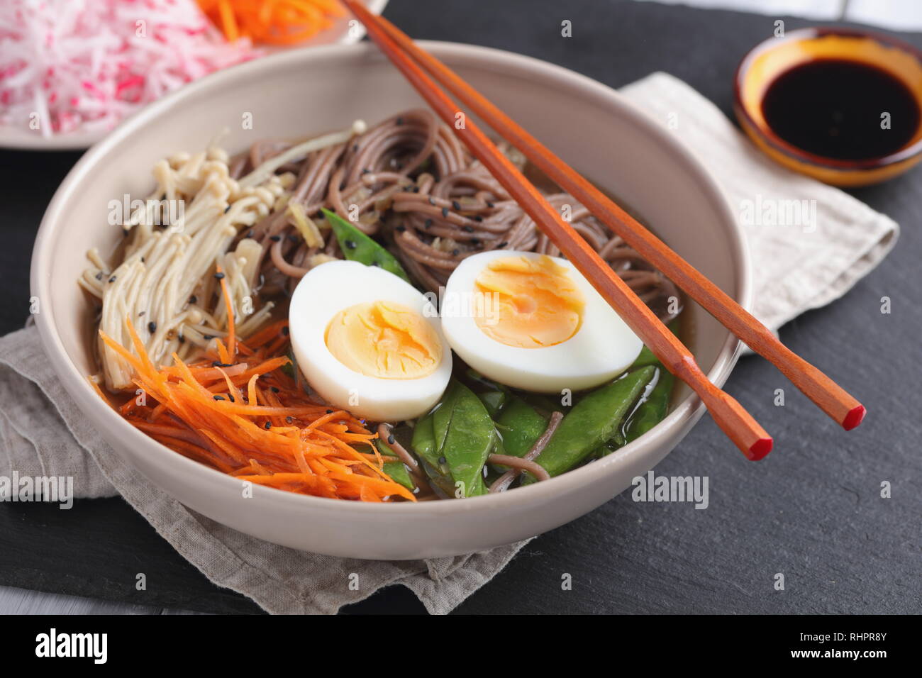 Japanese soup with Enoki mushrooms, soba noodles, boiled egg, carrot