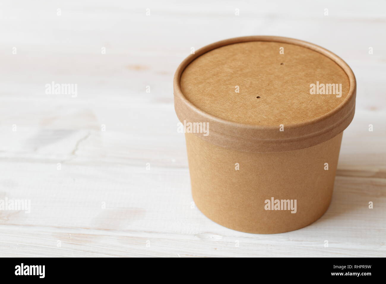 Kraft paper soup bowl with lid on a white table Stock Photo