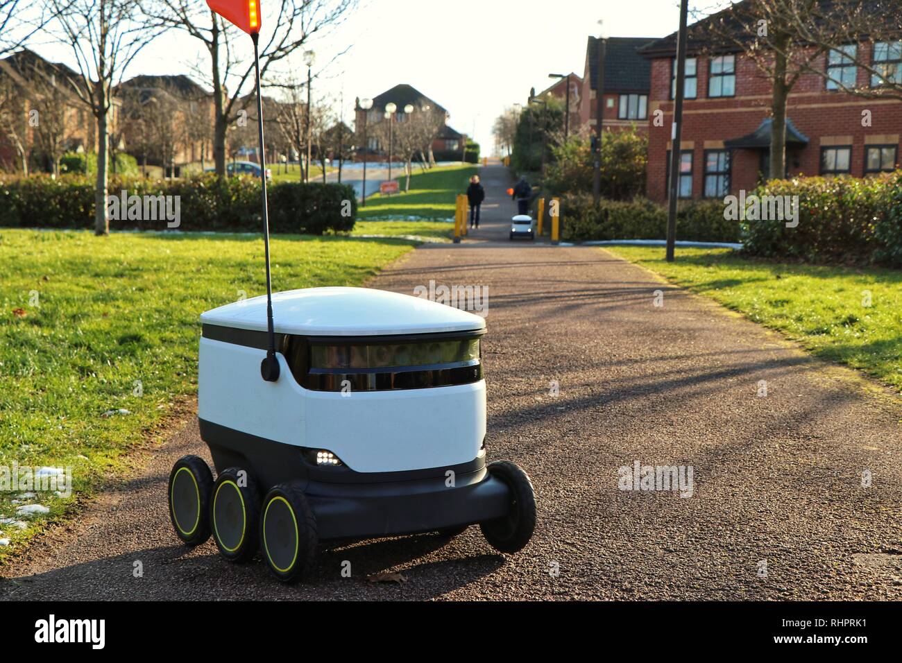 Pedestrians go about their daily lives as Starship Technologies autonomous robots make routine grocery deliveries around Milton Keynes. Stock Photo