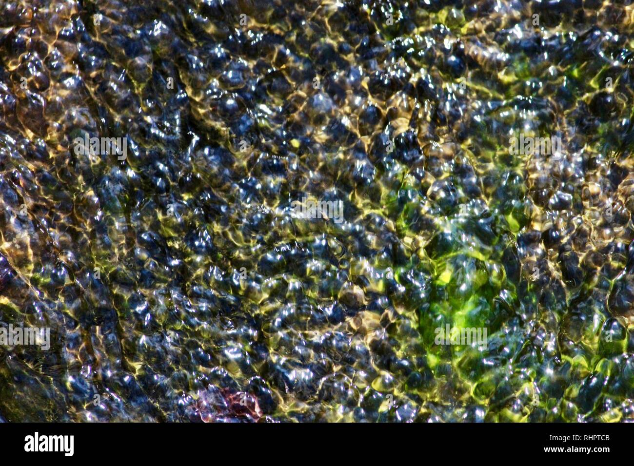 Water Ripples tinted yellow and green background texture Stock Photo