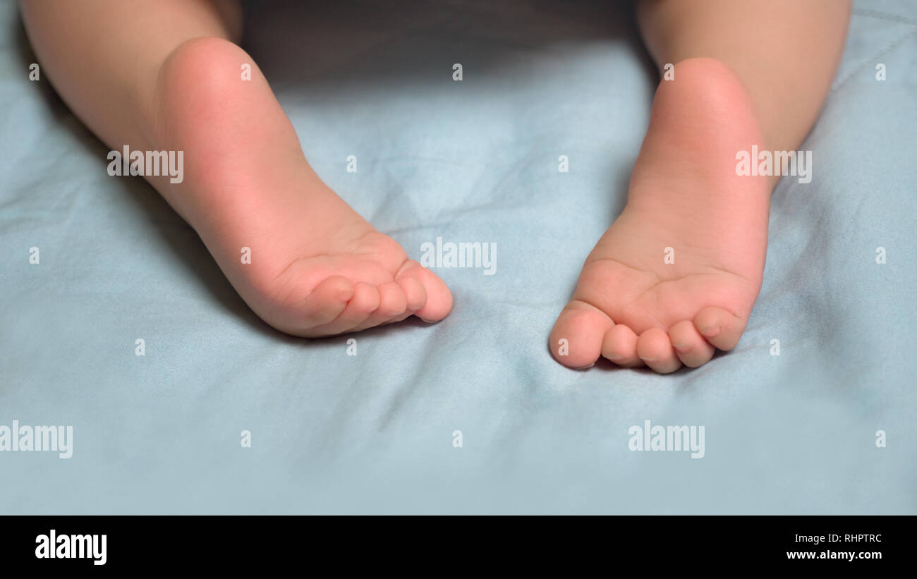 Early start. Infant's development in 7 12 months. Baby's closeup little barefeet. Children's