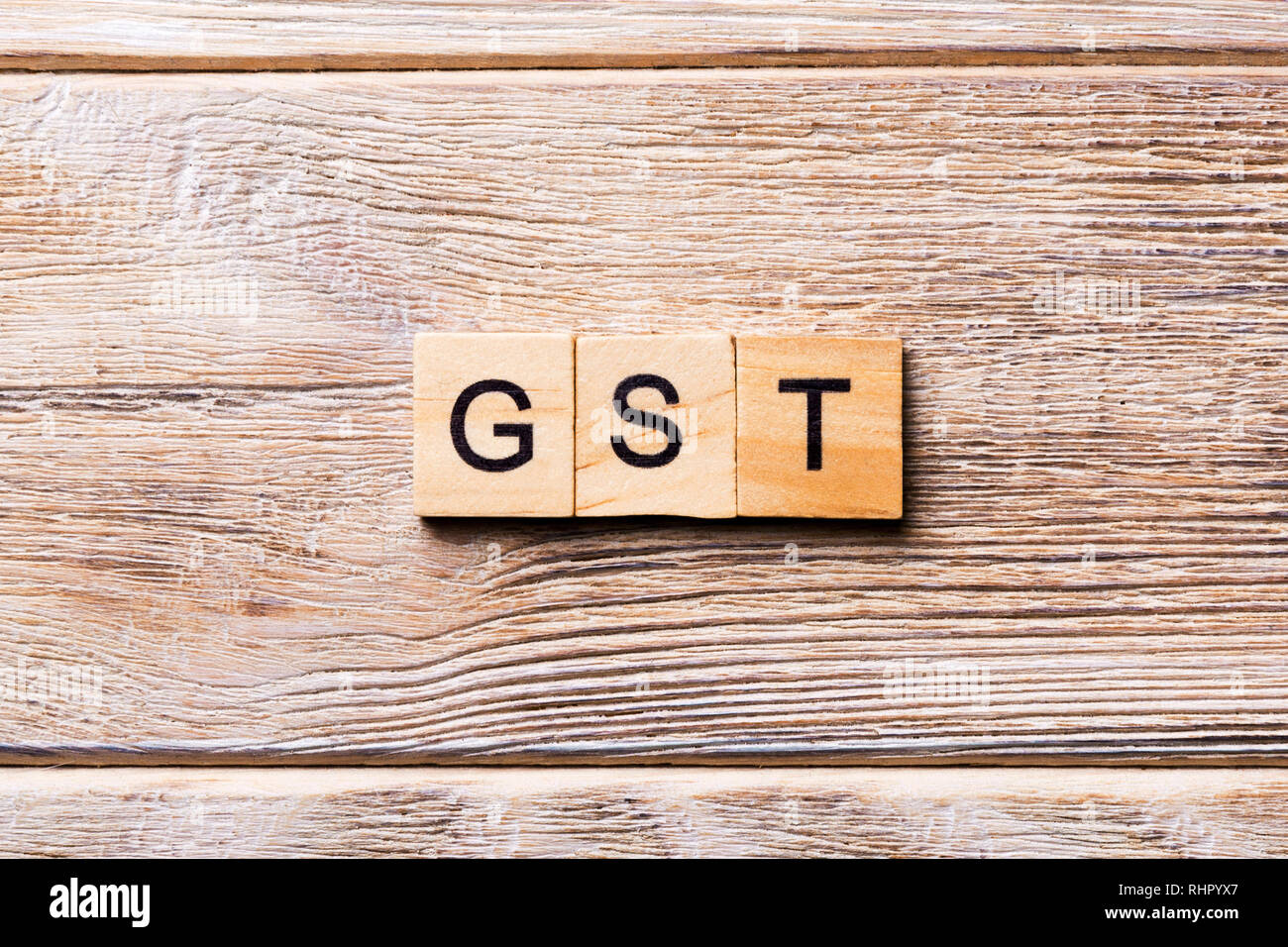 GST word written on wood block. GST text on wooden table for your