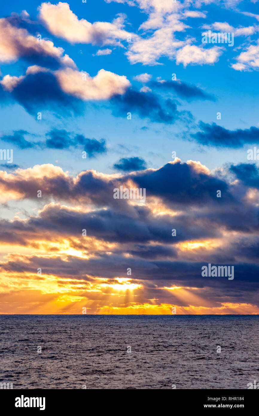 Suns rays coming from behind clouds as the sun is setting. Nortrh Atlantic Ocearn from the decks of P&O Arcadia on it's Christmas and New Year cruise Stock Photo