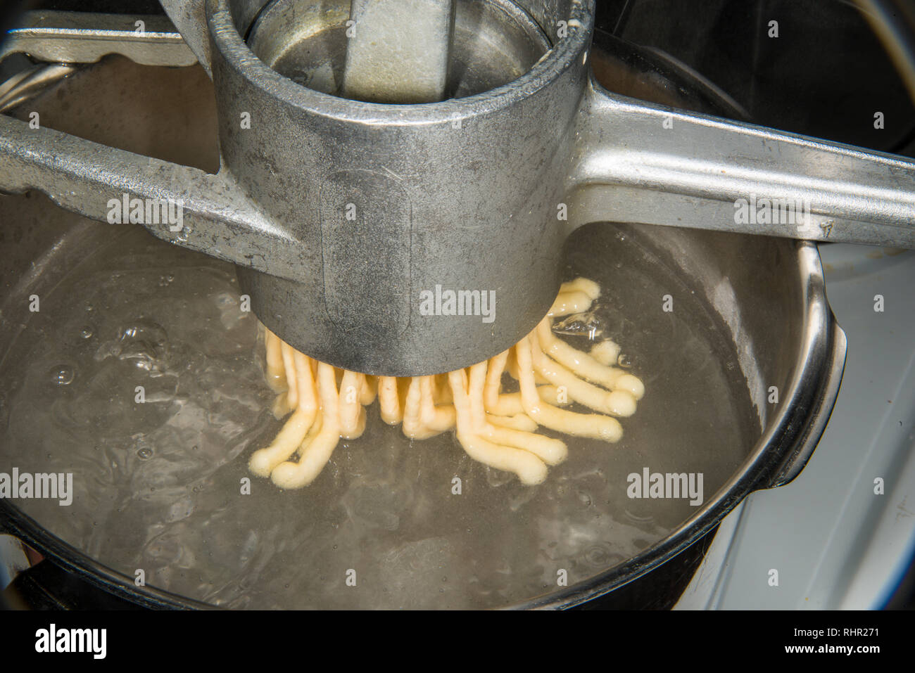 German noodle machine for spaetzle pressing noodles in cooking water Stock Photo