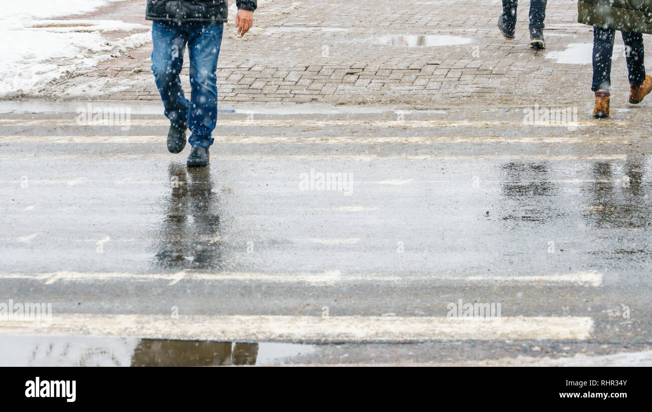 Winter City Slippery Sidewalk. Feet of people walking along the icy