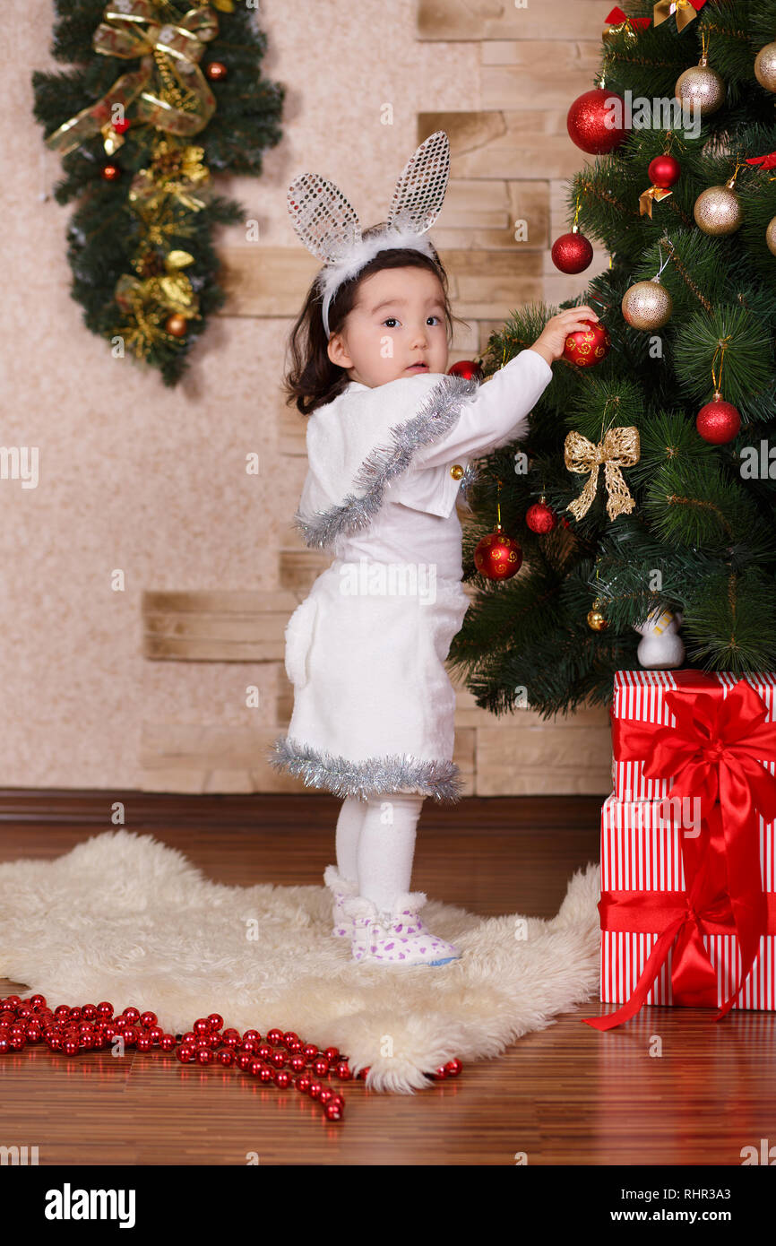Asian little cute girl wearing casual dress posing close to new year  christmas green classic tree with balls toys and colourful presents.Happy  holiday Stock Photo - Alamy